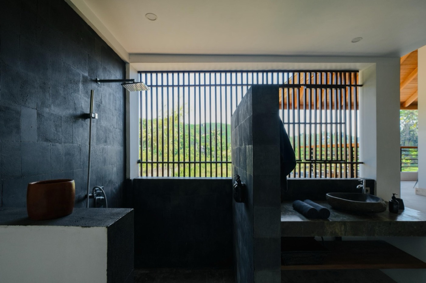 a dark stone bathroom with a rain shower