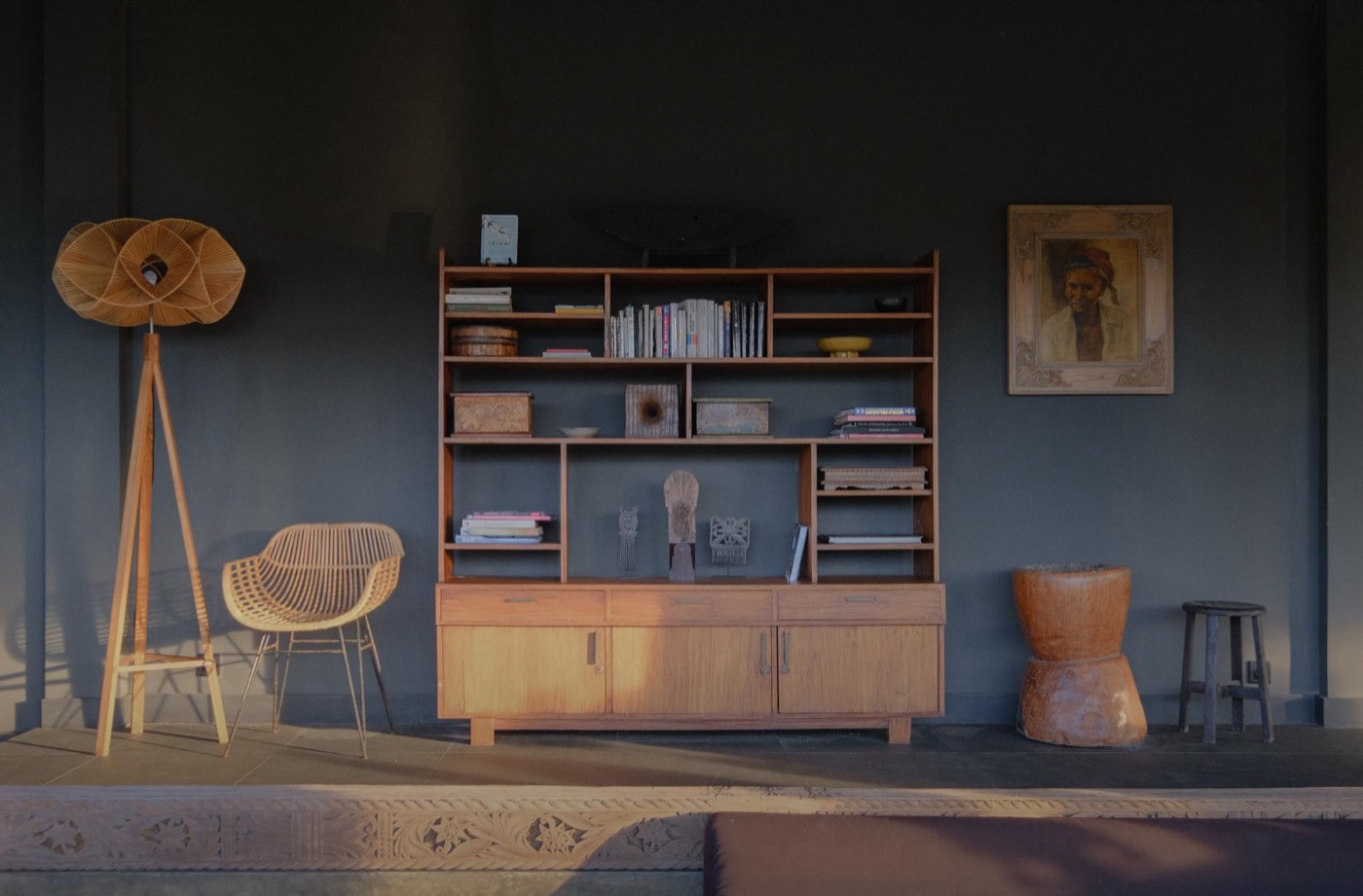 a bookshelf, a rattan chair and a floor lamp