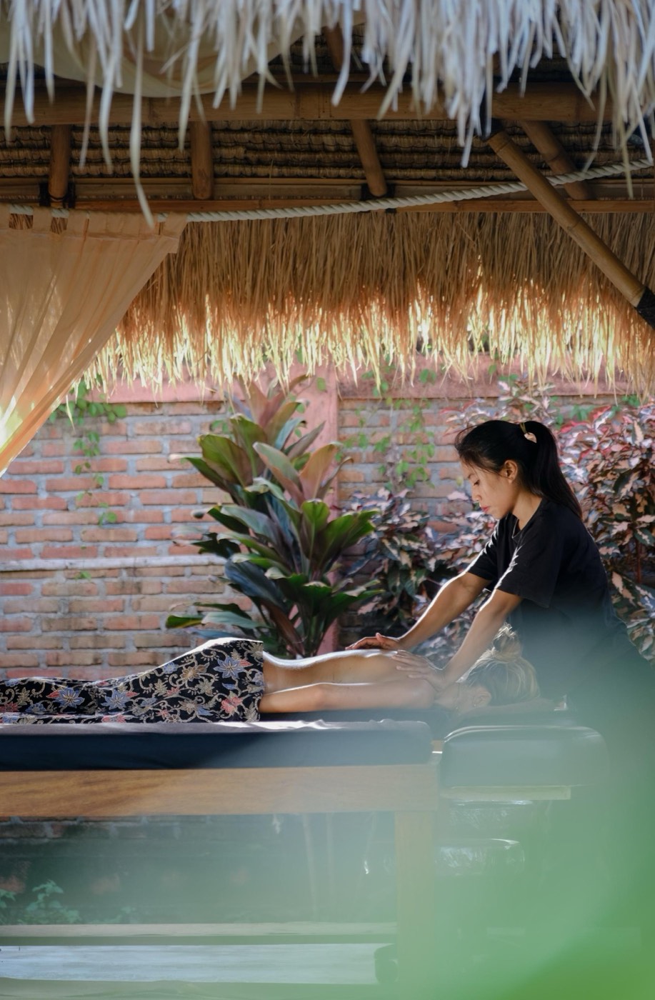 a massage in a thatched pavilion in the garden